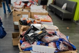 Pace University's mobile food pantry displays a variety of free food items, including plastic-wrapped cuts of meat.